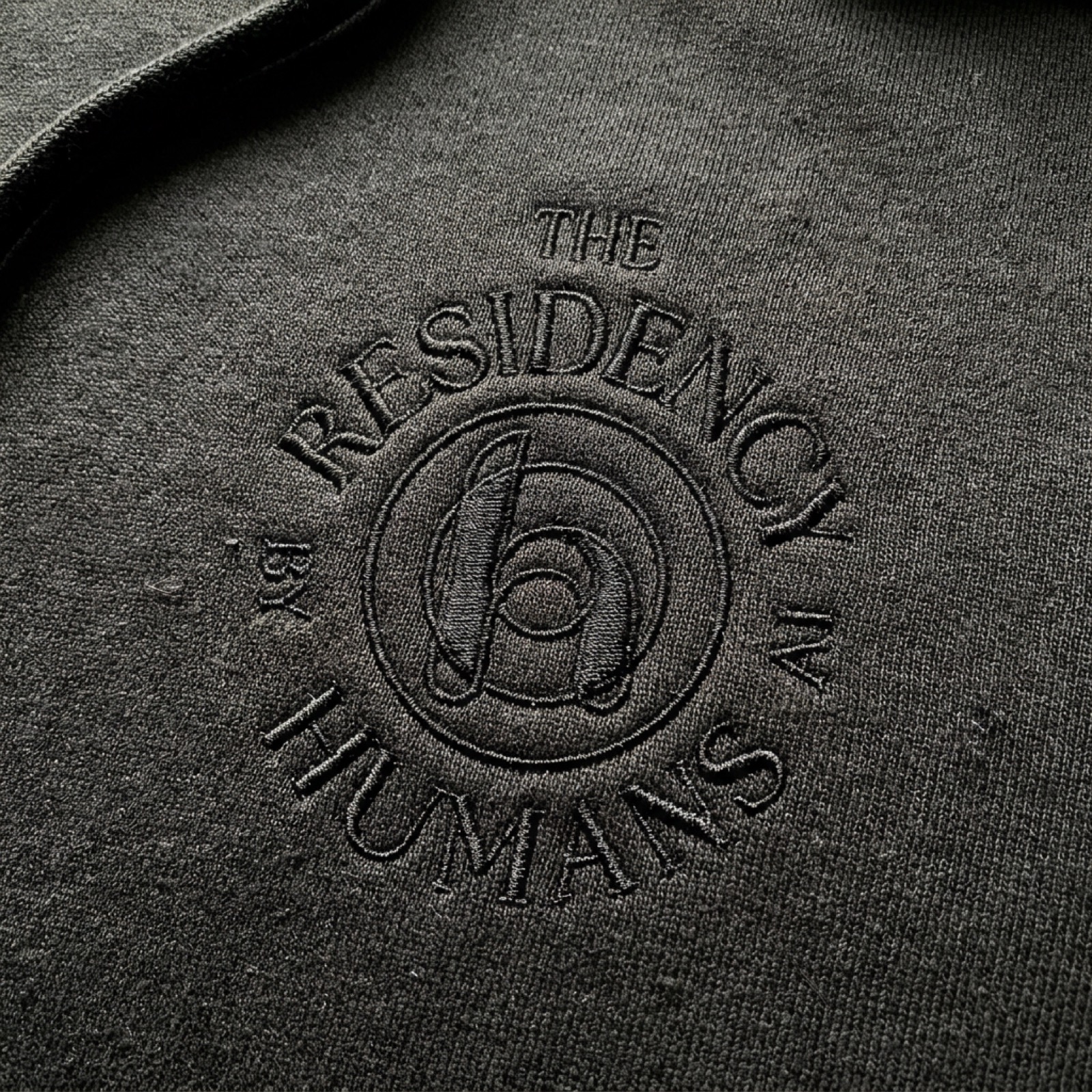 The Residency seal embroidered on a black hoodie